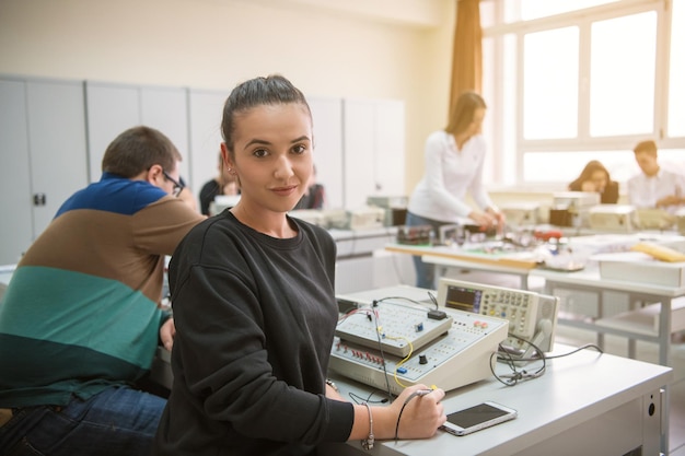 Groupe de jeunes étudiants faisant de la pratique professionnelle technique avec un enseignant dans la salle de classe électronique, concept d'éducation et de technologie