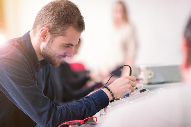 Photo groupe de jeunes étudiants faisant de la pratique professionnelle technique avec un enseignant dans la salle de classe électronique, concept d'éducation et de technologie