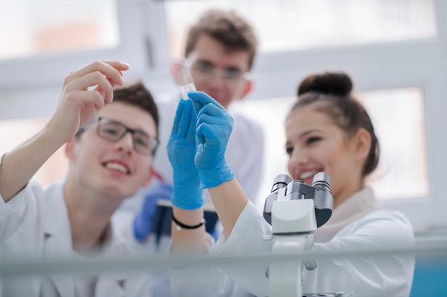 Groupe de jeunes étudiants en médecine faisant des recherches ensemble dans un laboratoire de chimie, travail d'équipe par un étudiant à l'intérieur