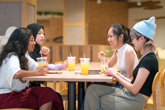 Groupe de jeunes femmes asiatiques s'amusant dans un café