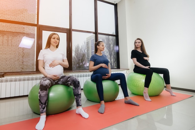 Un groupe de jeunes femmes enceintes pratiquent le Pilates et les sports de balle dans un club de fitness. Enceinte.