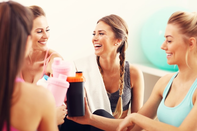 groupe de jeunes femmes se reposant à la salle de sport après l'entraînement