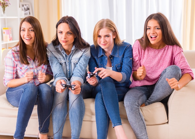 Groupe de jeunes filles assis sur le canapé à la maison.