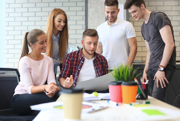 Groupe de jeunes gens d'affaires et designers. Ils travaillent sur un nouveau projet. Concept de démarrage.