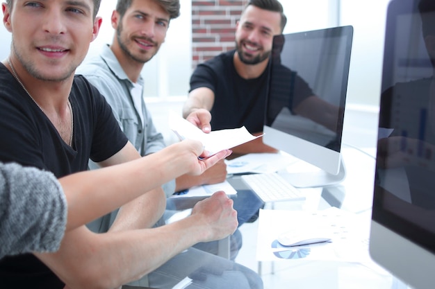 Groupe d&#39;un jeunes gens d&#39;affaires discutant de plan d&#39;affaires au bâtiment moderne de bureaux de démarrage