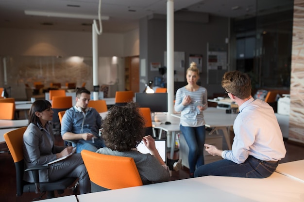 Groupe de jeunes gens d'affaires discutant d'un plan d'affaires au bureau