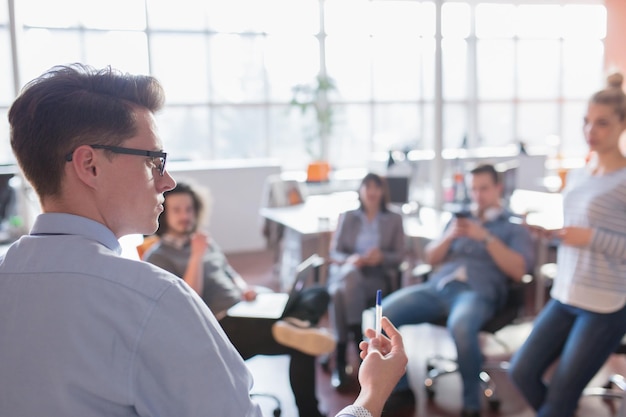 Groupe de jeunes gens d'affaires discutant d'un plan d'affaires au bureau