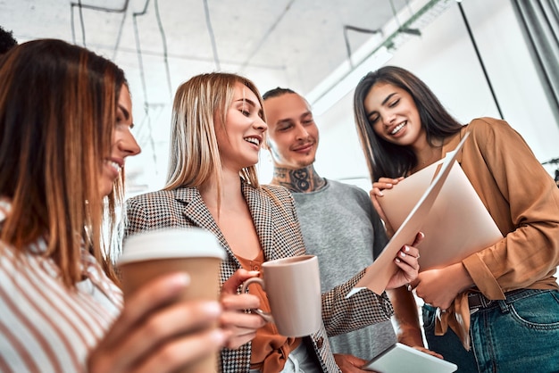 Groupe de jeunes gens d'affaires réunis pour discuter d'idées créatives et boire du café