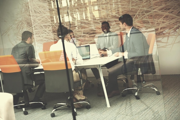 Un groupe de jeunes gens d'affaires se réunit et travaille dans un bureau moderne et lumineux à l'intérieur