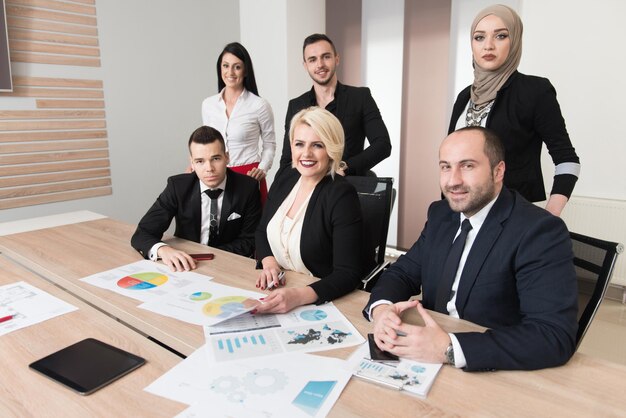 Un groupe de jeunes gens d'affaires se réunit et travaille dans un bureau moderne et lumineux à l'intérieur