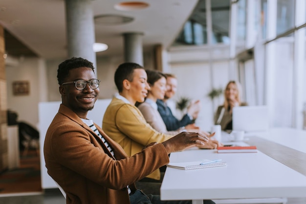 Groupe de jeunes gens d'affaires travaillant ensemble et préparant un nouveau projet lors d'une réunion au bureau