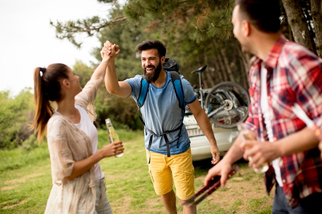 Groupe de jeunes gens appréciant la fête de barbecue dans la nature