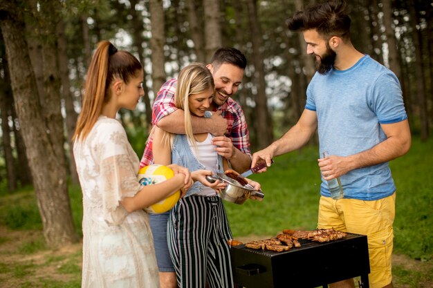 Groupe de jeunes gens appréciant la fête de barbecue dans la nature