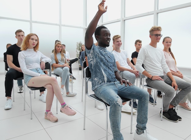 Groupe de jeunes gens divers assis dans une salle de conférence