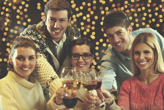 Groupe de jeunes gens heureux boivent du vin au restaurant disco party