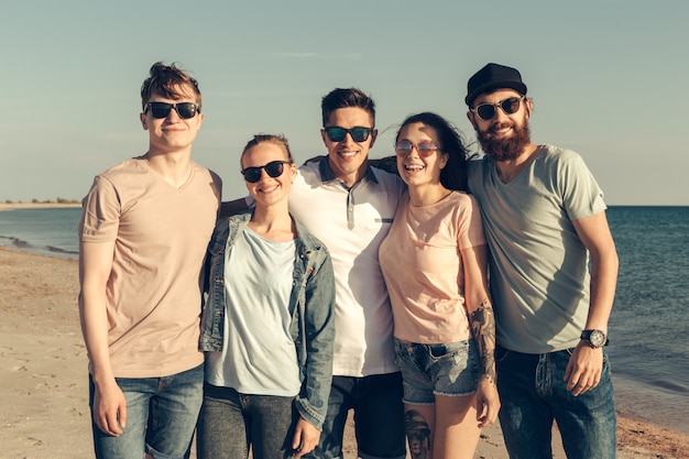 Groupe de jeunes gens profitent d&#39;une fête d&#39;été à la plage