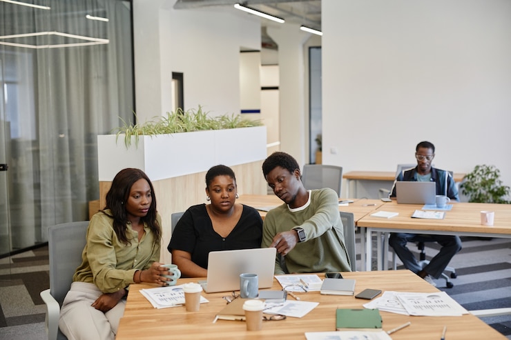 Photo groupe de jeunes hommes d'affaires noirs regardant la présentation du produit sur l'écran d'un ordinateur portable lors d'une réunion