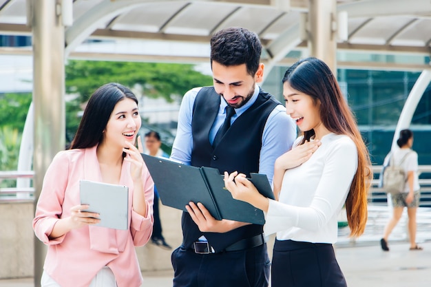 Un groupe de jeunes jeunes multiethniques sont heureux de regarder un dossier