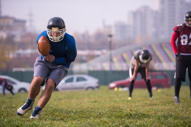 groupe de jeunes joueurs de football américain en action pendant l'entraînement sur le terrain