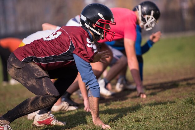 groupe de jeunes joueurs de football américain en action pendant l'entraînement sur le terrain