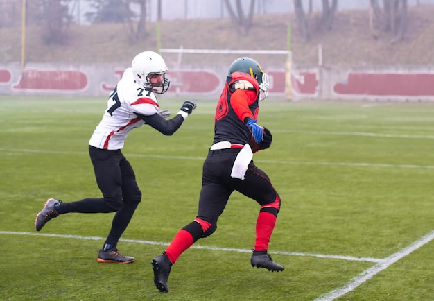 groupe de jeunes joueurs professionnels de football américain en action lors d'un match d'entraînement sur le terrain du stade