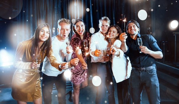 Un groupe de jeunes joyeux font la fête et célèbrent le nouvel an à l'intérieur.