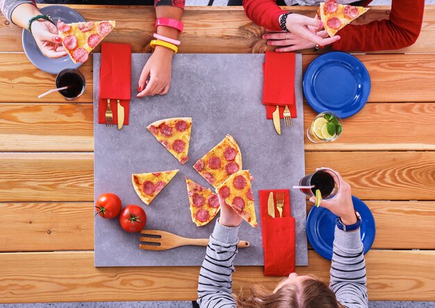 Groupe de jeunes mangeant de la pizza au bureau