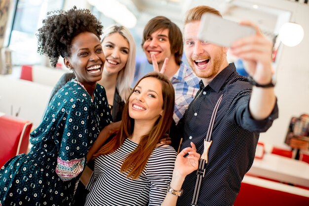 Groupe de jeunes prenant selfie avec un téléphone portable