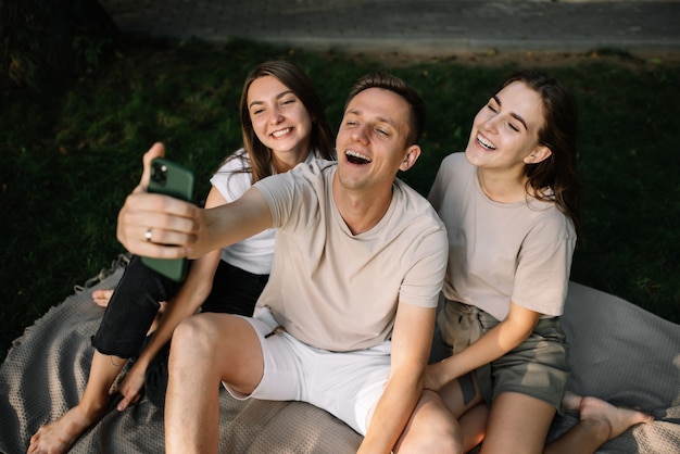 Un groupe de jeunes prenant des selfies dans la nature dans le parc