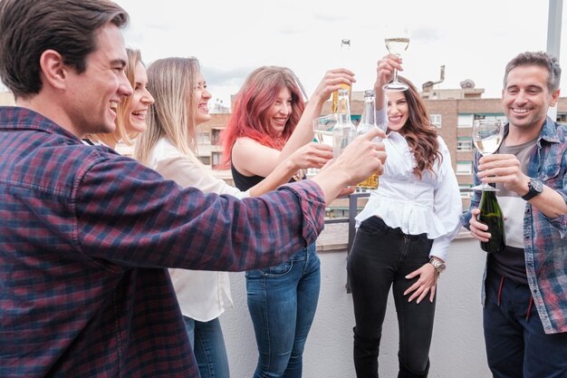 Un groupe de jeunes qui font un toast sur la terrasse pour célébrer ensemble leurs succès.