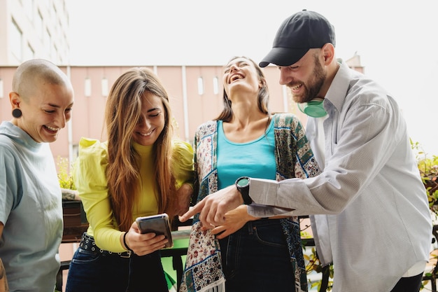 Groupe de jeunes s'amusant à regarder du contenu amusant en ligne via le smartphone.