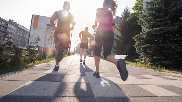 groupe de jeunes sportifs faisant du jogging le matin ensoleillé de la ville
