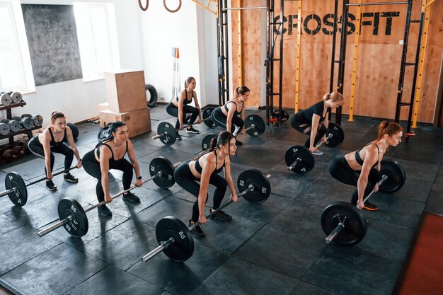 Un groupe de jeunes sportifs ont une journée de crossfit à l'intérieur du gymnase.