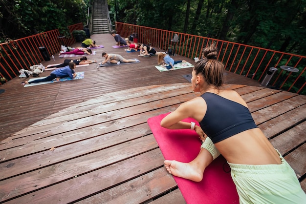 Groupe de jeunes sportifs pratiquant une leçon de yoga avec instructeur