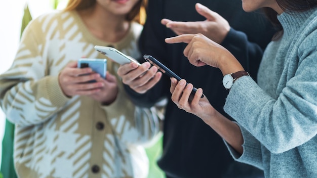 Groupe de jeunes utilisant et regardant ensemble un téléphone portable