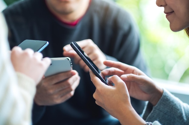 Groupe de jeunes utilisant et regardant ensemble un téléphone portable