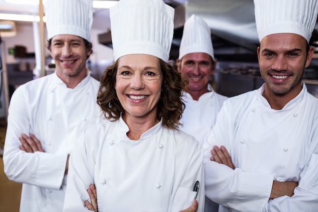 Groupe de joyeux chefs souriant à la caméra