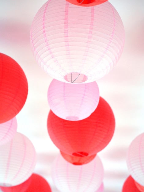 Groupe de lanternes en papier rouges et roses accrochées au plafond pour la décoration du festival des vacances de la Saint-Valentin et du nouvel an chinois.