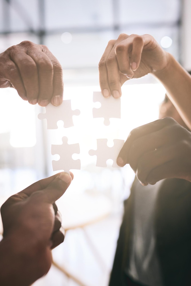 Photo groupe de mains et de personnes avec un puzzle au bureau pour le travail d'équipe résolution de problèmes et soutien à l'intégration jeu de puzzle du personnel ou collaboration pour la productivité synergie et solution de croissance de l'équipe