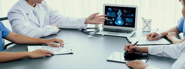 Un groupe de médecins ou de chercheurs étudiant les maladies génétiques de l'ADN avec un ordinateur portable analyse les données génétiques, formule des stratégies de traitement médical et élabore un plan de soins de santé avec une solution innovante Neoteric