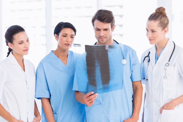Groupe de médecins et de chirurgiens examinant les rayons X
