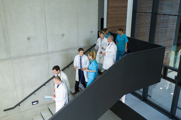 Groupe de médecins et chirurgiens interagissant les uns avec les autres sur l'escalier