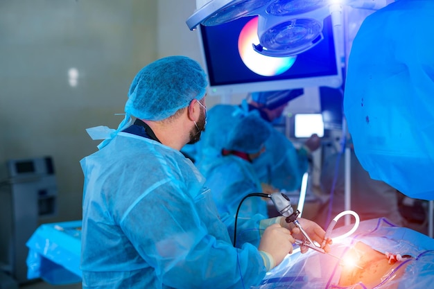 Groupe de médecins effectuent une opération à un patient Chirurgiens en uniforme médical et masques travaillant dans la salle d'opération