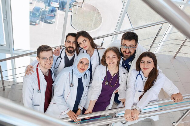 Un groupe de médecins heureux et souriants dans le couloir de l'hôpital étudiants en médecine de différentes races kapmus