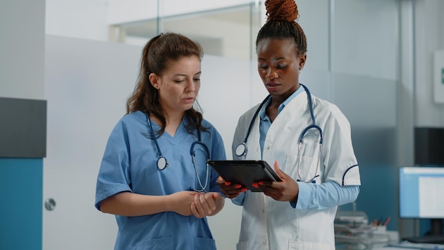 Groupe de médecins et d'infirmières analysant le diagnostic sur tablette