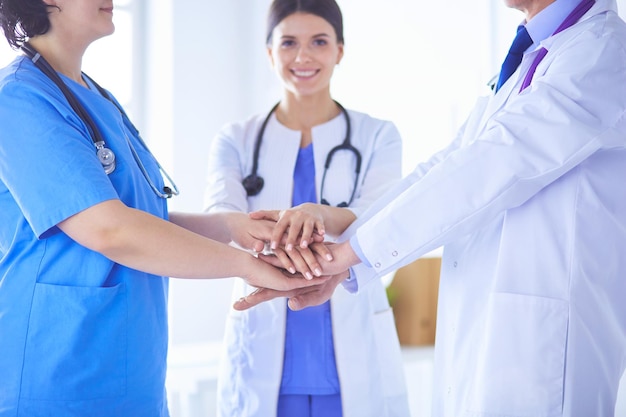 Groupe de médecins mettant leurs mains ensemble Gros plan