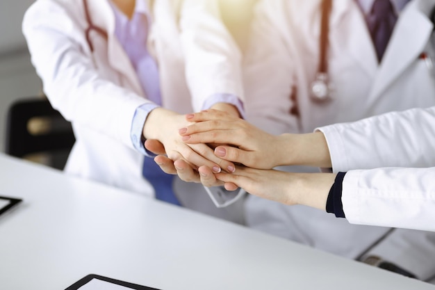 Groupe de médecins modernes se donnant la main en cercle. Travail d'équipe en médecine pendant la pandémie de coronavirus, covid 2019.