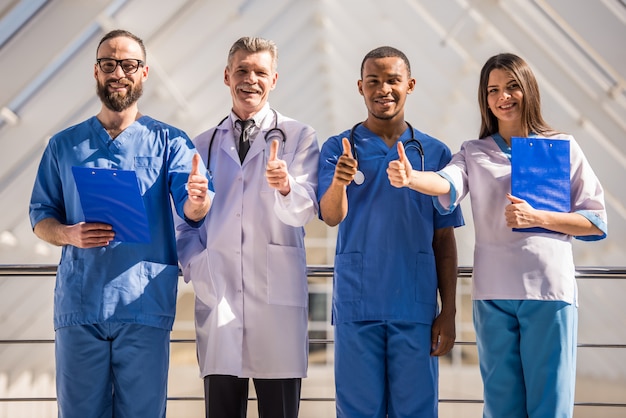 Groupe de médecins montrant les pouces vers le haut à l'hôpital.