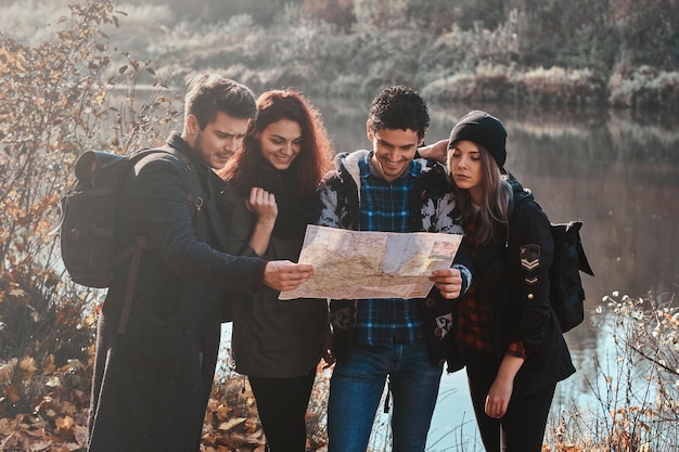 Un groupe de meilleurs amis cherche la bonne direction dans la forêt d'automne.