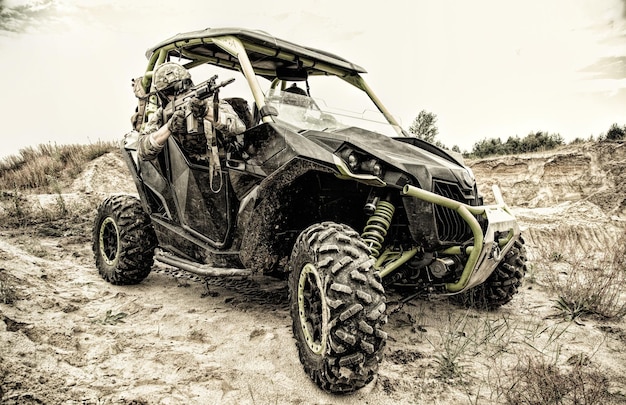 Groupe mobile de forces d'opérations spéciales, patrouille militaire, équipe de combat à réaction rapide se déplaçant sur un véhicule léger du désert dans une zone sablonneuse. Véhicule tout-terrain de vitesse de l'armée moderne, buggy de combat sur le champ de bataille